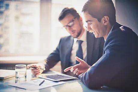 Two professionals using a tablet to discuss employee motivation and retention strategies.
