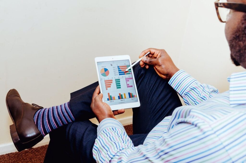 Business professional analysing workplace performance charts on a tablet at People Management Partners.
