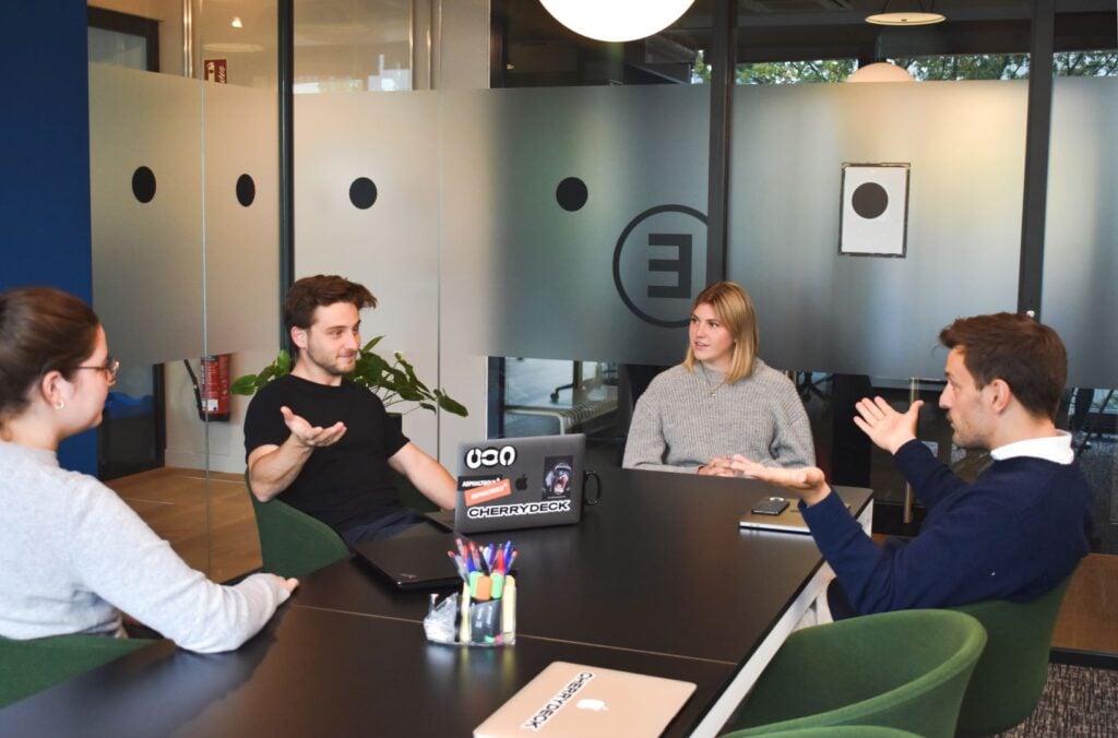 Four people engaged in a discussion at a team meeting.