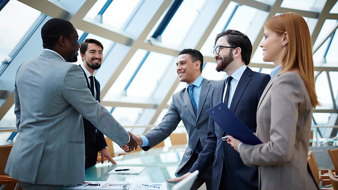 Business professionals shaking hands during a formal agreement meeting in a corporate setting.